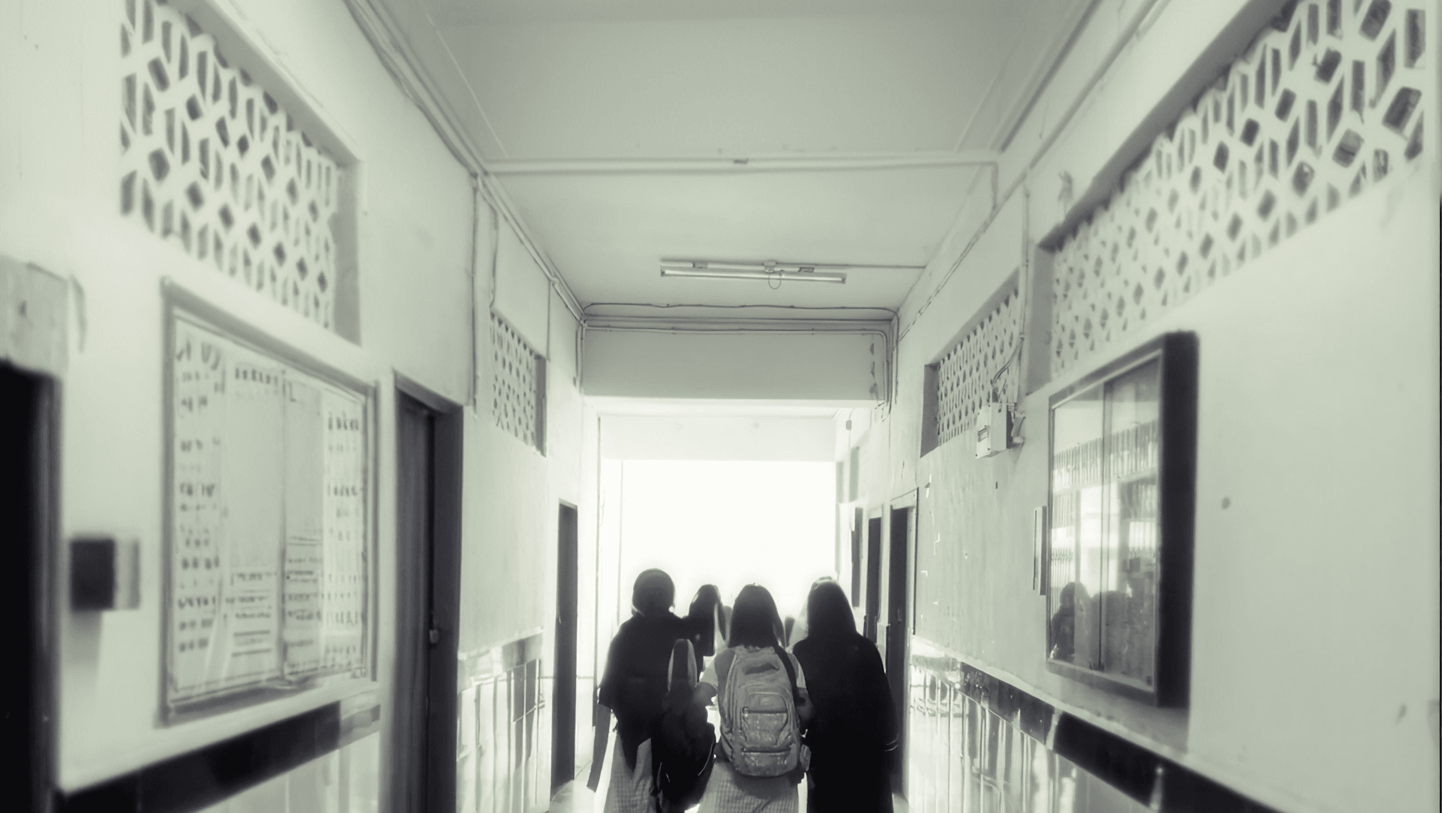 Students walking down a school corridor, under the Draw the Line identity