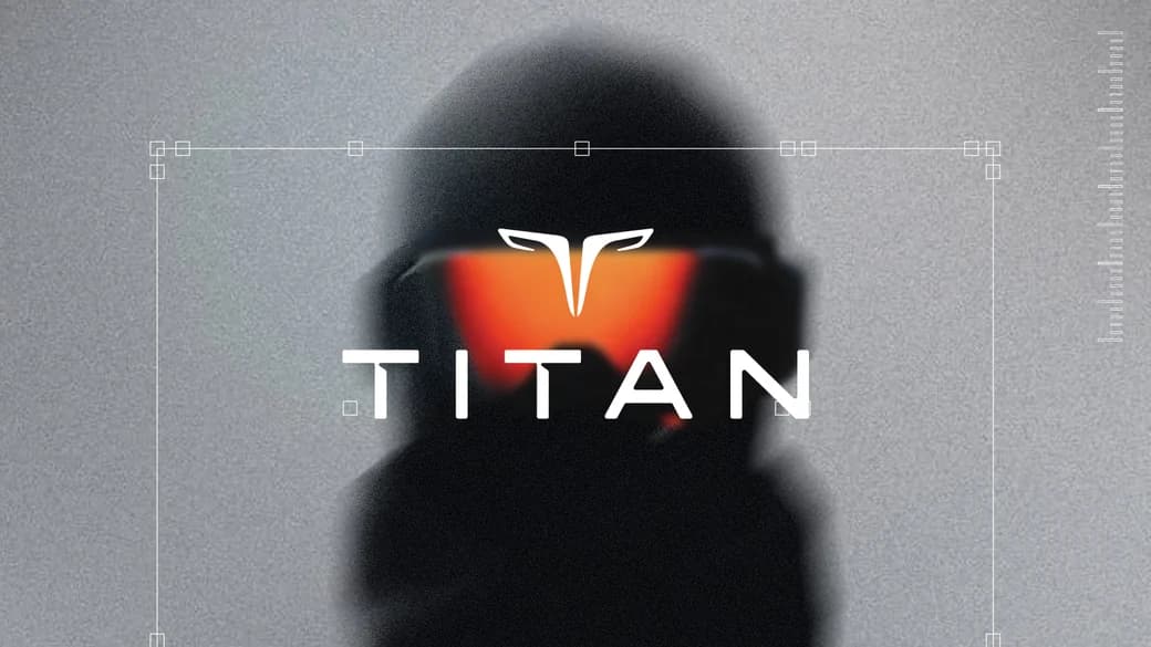 A figure in goggles catching an ember reflection, the TITAN lockup across it.