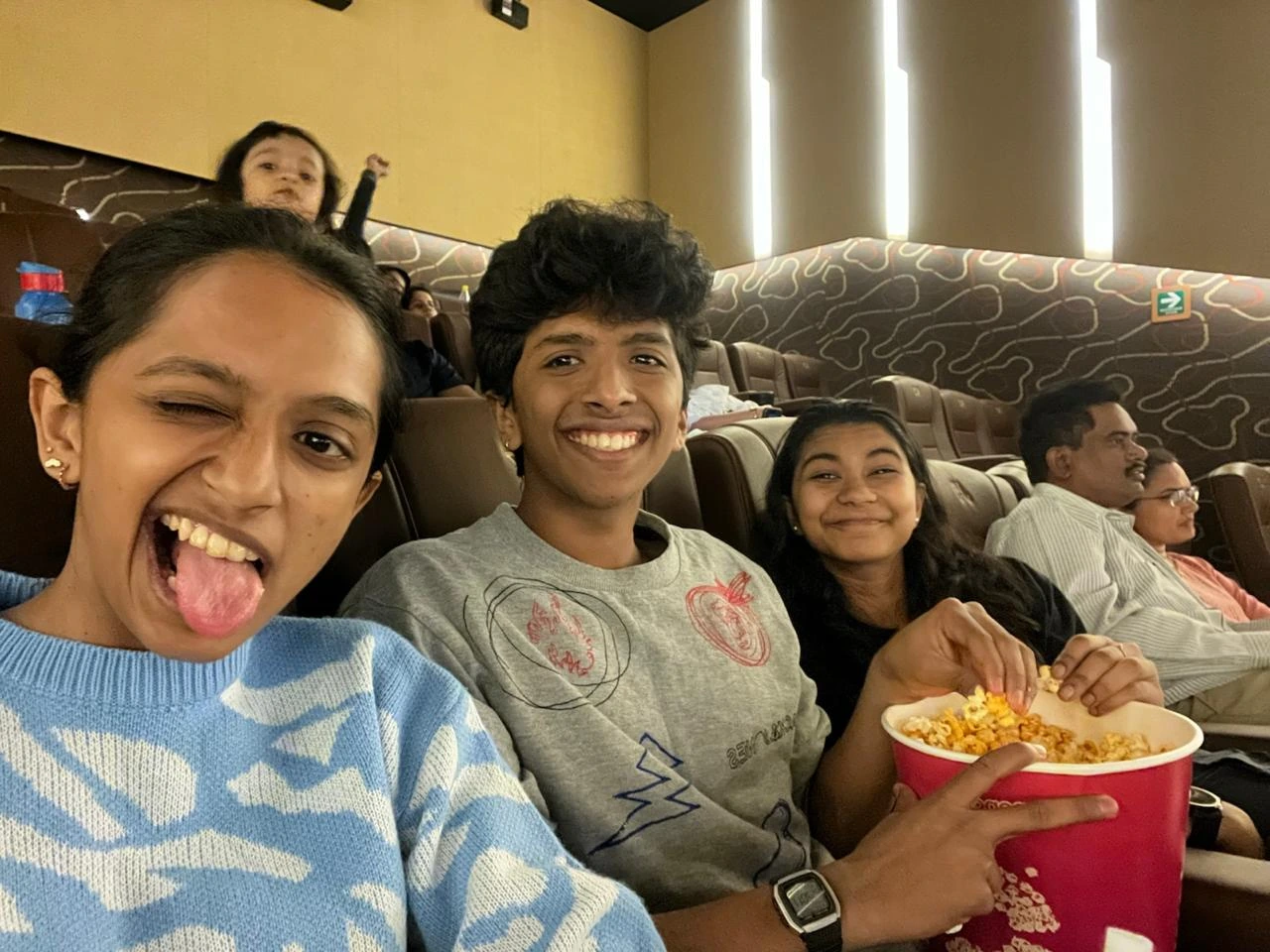 Melvis with family in a cinema, popcorn in hand